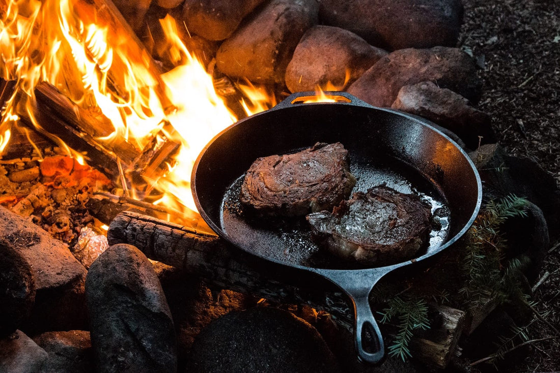 Steaks in einer Pfanne auf Lagerfeuer